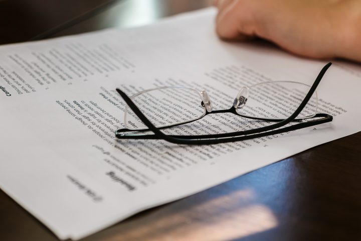 Auf dem Bild ist ein Dokument zu sehen auf dem eine Brille liegt.